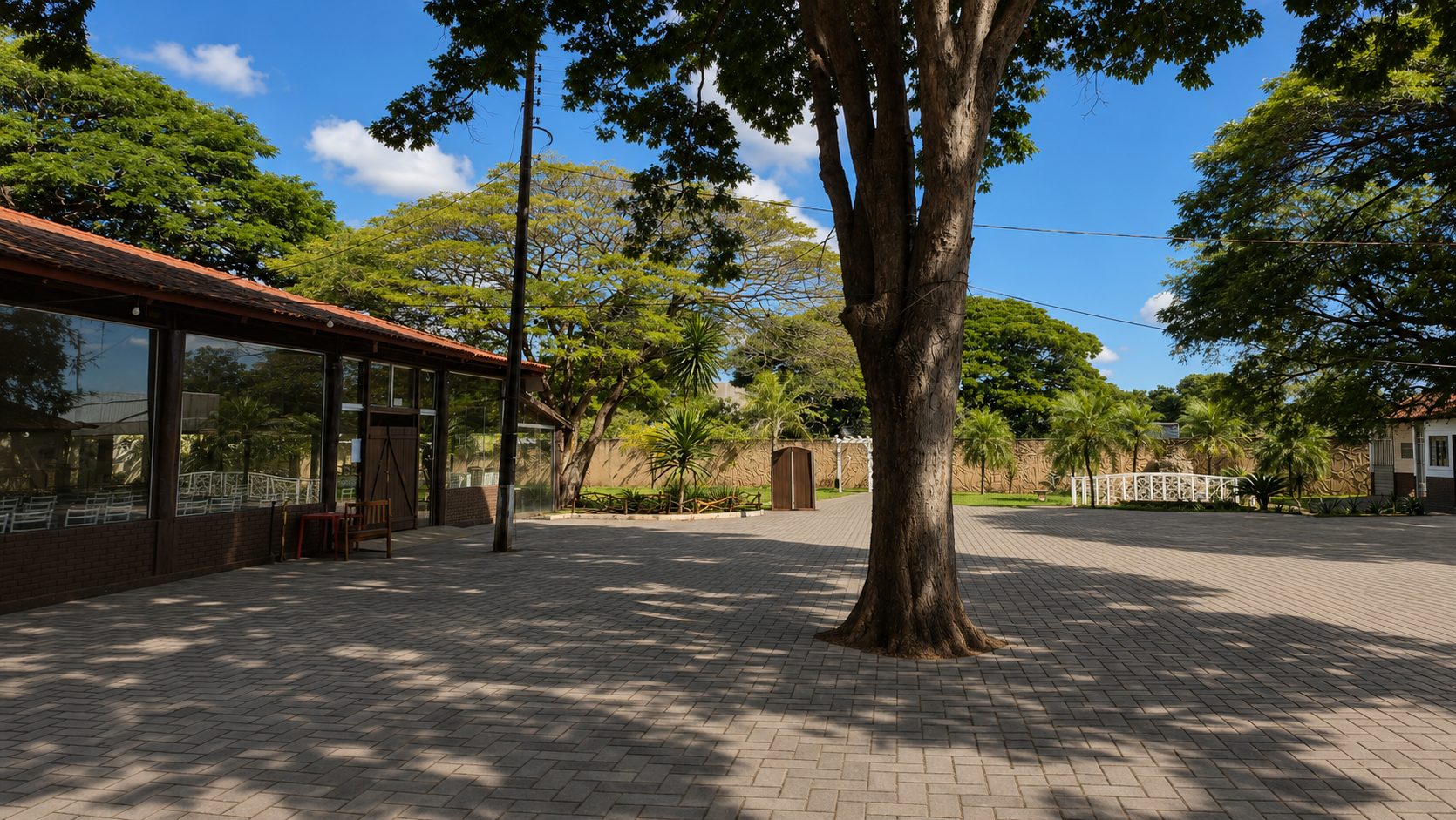 Área externa com salão de vidro e piso intertravado